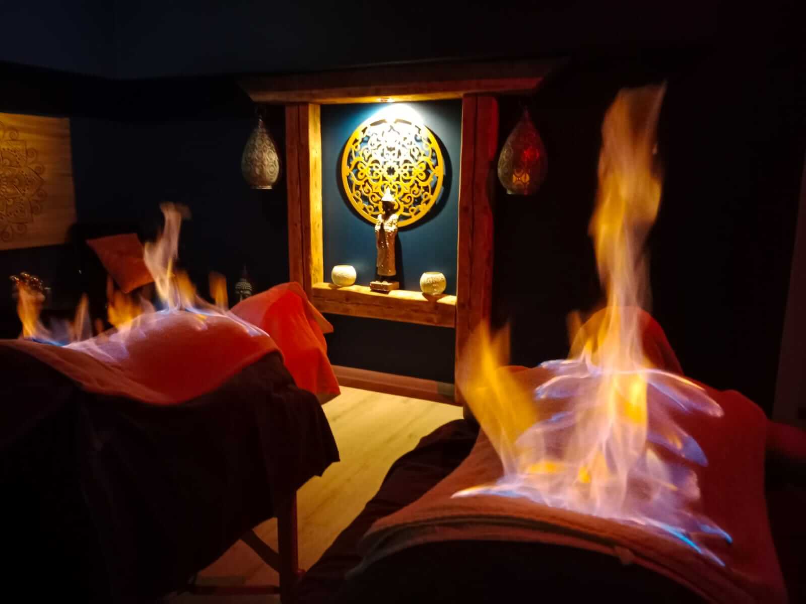 Zdjęcie ukazuje terapeutę przeprowadzającego tybetański masaż ogniem w gabinecie Oriental SPA w Jeleniej Górze. Terapeuta delikatnie podgrzewa powierzchnię skóry pacjenta za pomocą specjalnych technik ogniowych, co pomaga w rozluźnieniu mięśni, poprawie krążenia i eliminacji toksyn. Pacjent leży na stole do masażu, a atmosfera gabinetu jest spokojna i bezpieczna, co sprzyja pełnej relaksacji i skuteczności zabiegu.